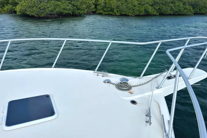 Slide: The Image of Bow of 1990 Viking 38 Convertible yacht on calm water near mangroves. - 24