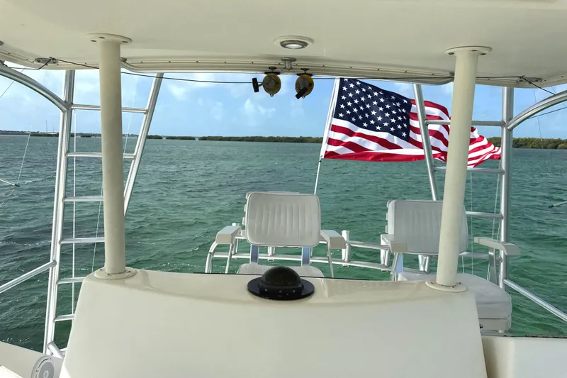Slide: The Image of 1990 Viking 38 Convertible boat with American flag on open water. - 40