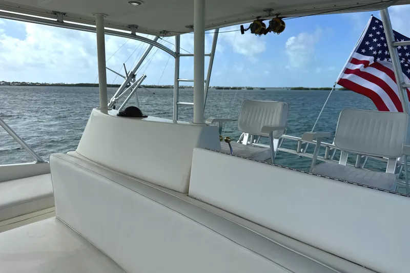 Slide: The Image of 1990 Viking 38 Convertible yacht interior with seating, ocean view, and American flag. - 41