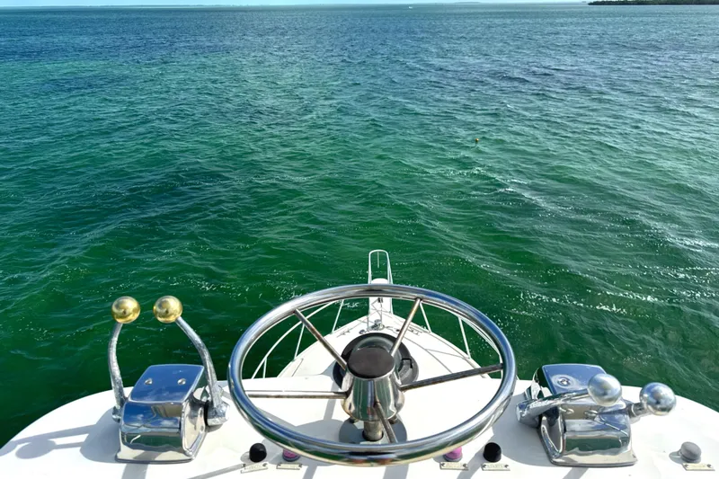 Slide: The Image of Helm of 1990 Viking 38 Convertible yacht overlooking calm ocean waters. - 44