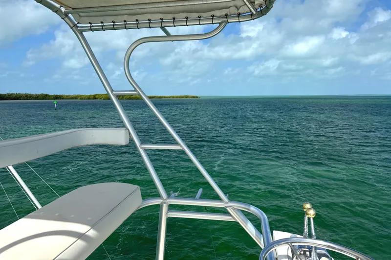 Slide: The Image of Viking 38 Convertible 1990 yacht overlooking serene ocean and blue sky. - 47
