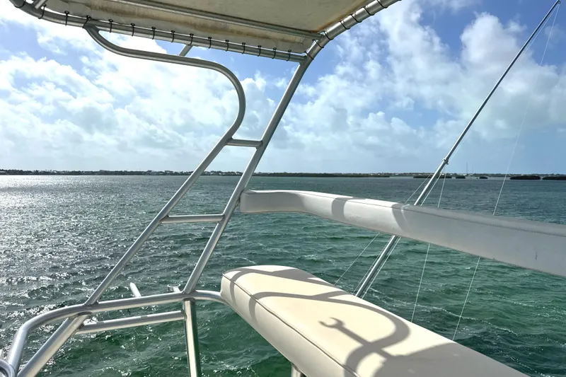 Slide: The Image of 1990 Viking 38 Convertible yacht overlooking serene ocean under blue sky. - 49