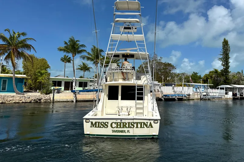 Slide: The Image of 1990 Viking 38 Convertible boat "Miss Christina" in a sunny marina setting. - 6