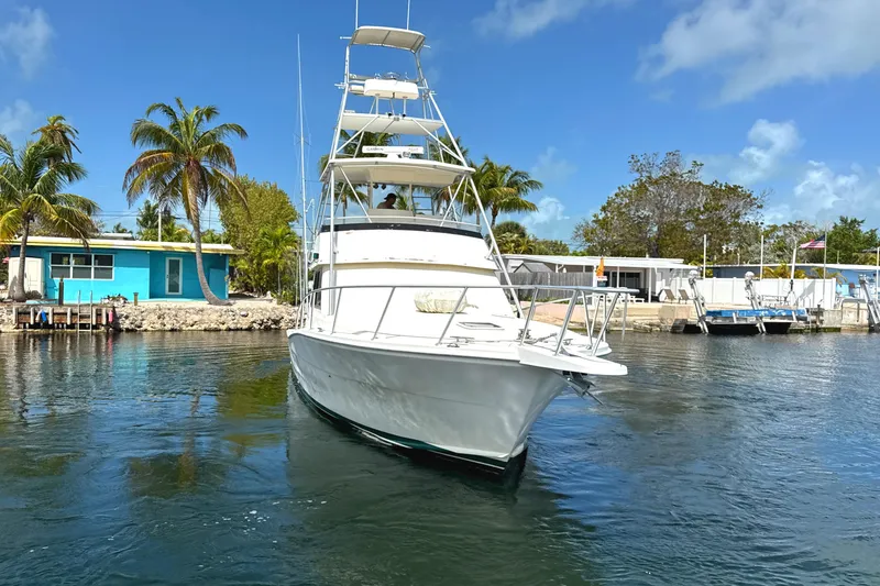 Slide: The Image of 1990 Viking 38 Convertible yacht on water, surrounded by palm trees and blue sky. - 9