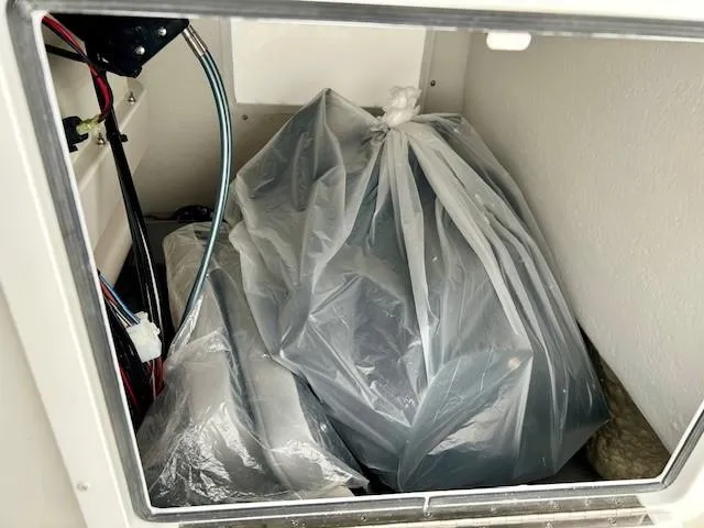 Slide: The Image of Storage compartment of 2024 Parker 1801 Center Console with plastic-covered items. - 13