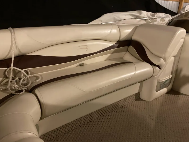 Slide: The Image of 2003 Bennington 2275RL boat interior with beige and brown seating. - 10