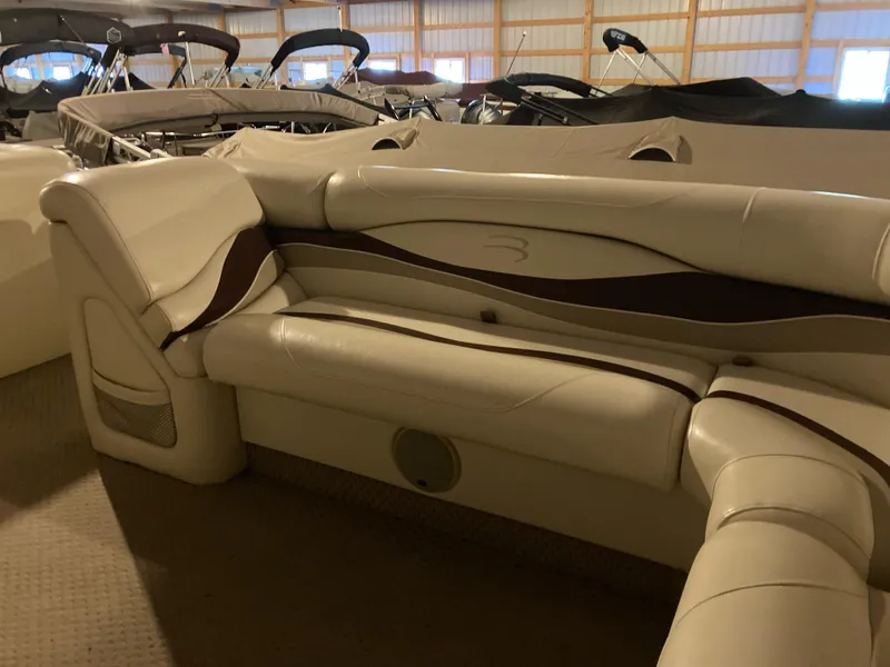Slide: The Image of 2003 Bennington 2275RL boat interior with beige seating in storage facility. - 11