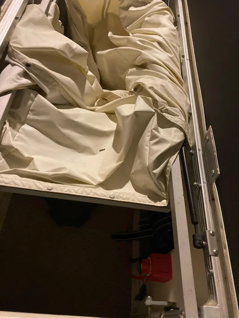 Slide: The Image of Storage compartment of a 2003 Bennington 2275RL boat with canvas cover. - 12