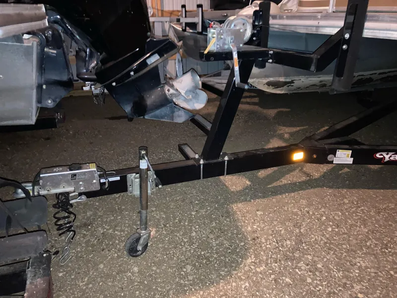 Slide: The Image of Trailer hitch and boat motor of a 2003 Bennington 2275RL on a gravel surface. - 17