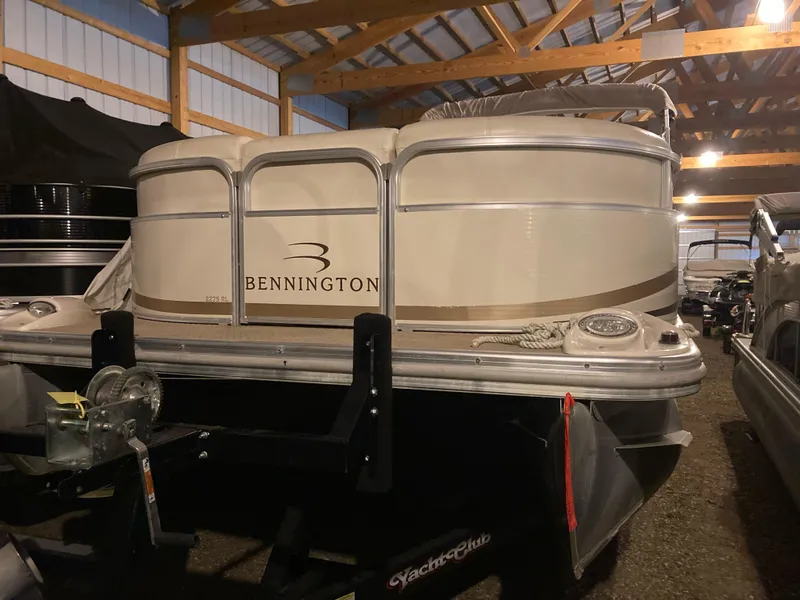 Slide: The Image of 2003 Bennington 2275RL pontoon boat in storage, featuring a beige exterior. - 3