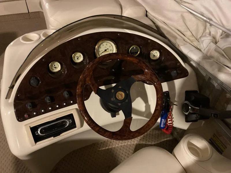 Slide: The Image of Steering console of a 2003 Bennington 2275RL boat with wood accents and gauges. - 6