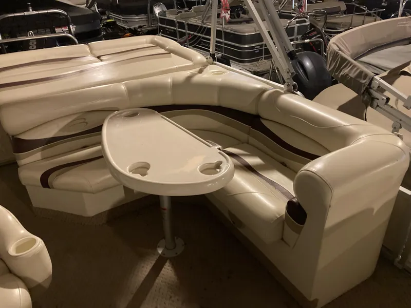 Slide: The Image of 2003 Bennington 2275RL boat interior with beige seating and table. - 7