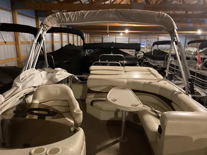 Slide: The Image of 2003 Bennington 2275RL pontoon boat with beige seating, stored indoors. - 8
