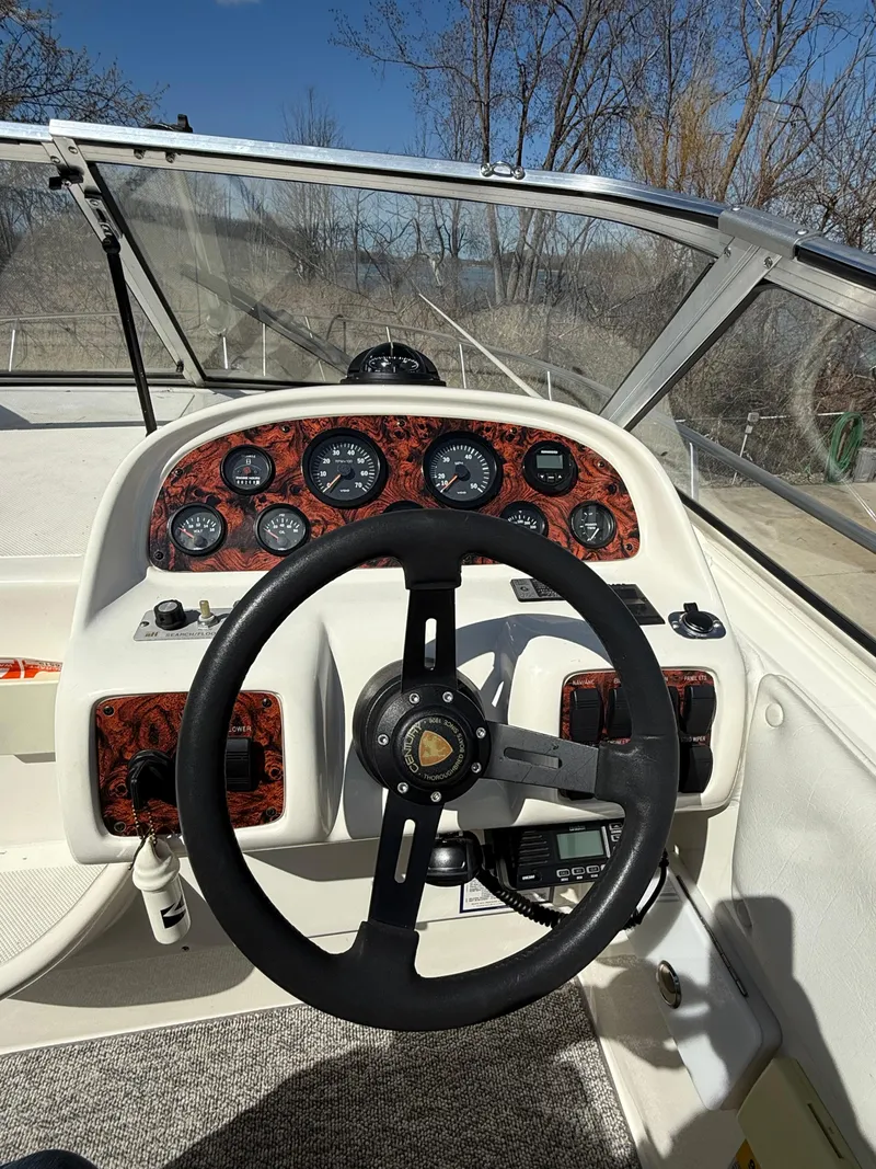 Slide: The Image of Steering wheel and dashboard of a 1992 Century Antigua 235 boat, featuring classic gauges. - 10