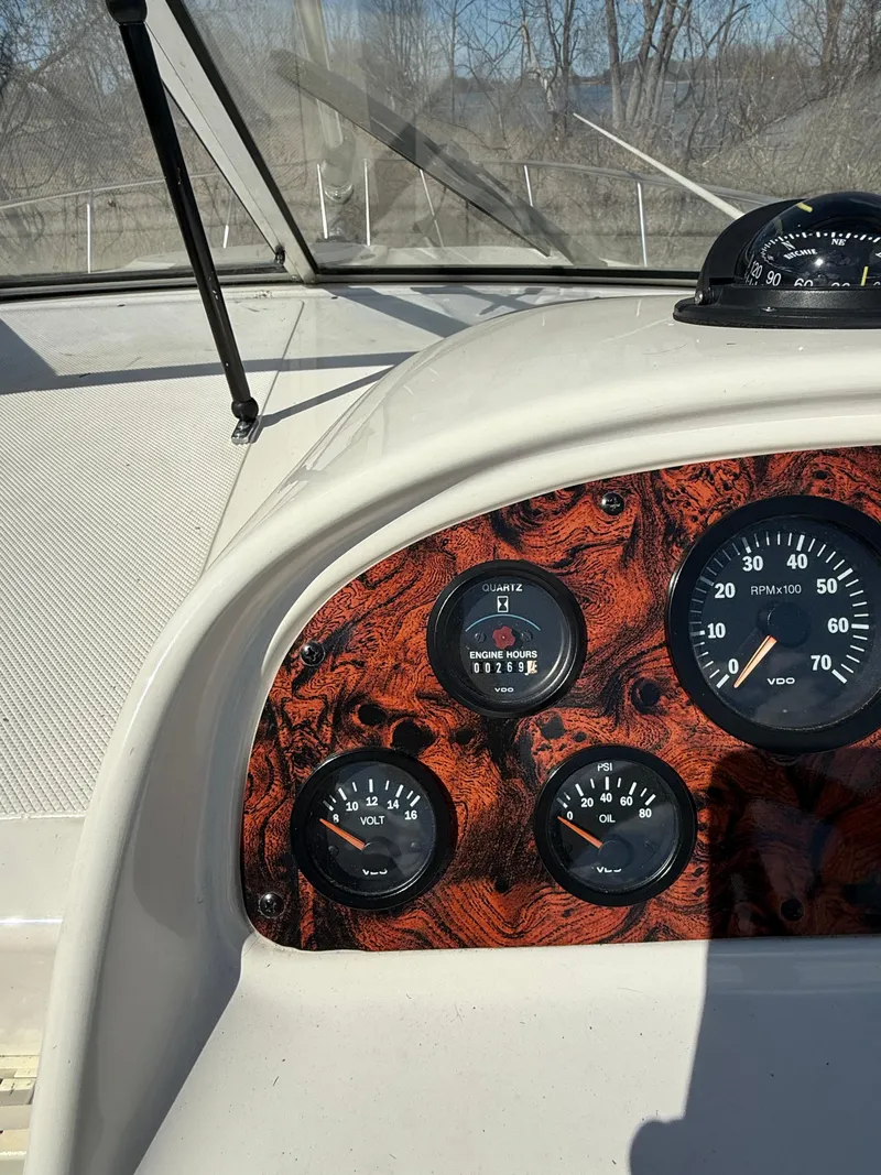 Slide: The Image of Dashboard of a 1992 Century Antigua 235 boat with wood grain paneling and gauges. - 11