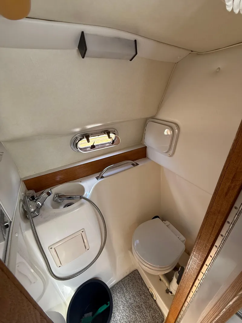Slide: The Image of 1992 Century Antigua 235 boat bathroom with toilet, sink, and window. - 17