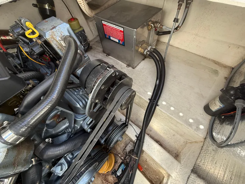 Slide: The Image of Engine compartment of a 1992 Century Antigua 235 boat, showing mechanical components and hoses. - 21