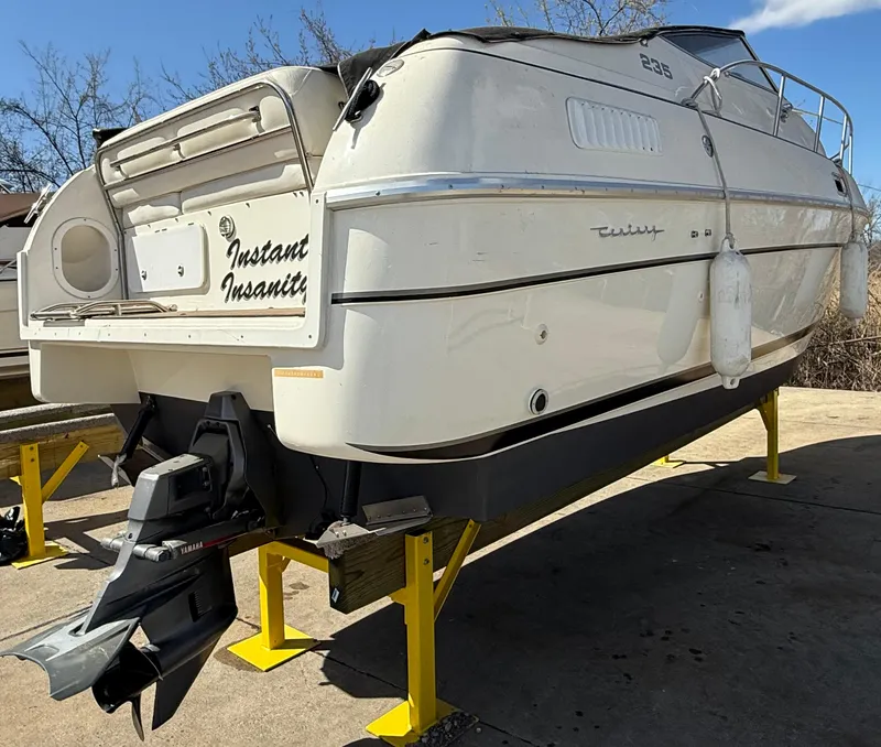 Slide: The Image of 1992 Century Antigua 235 boat on stands, named "Instant Insanity," with visible outboard motor. - 3