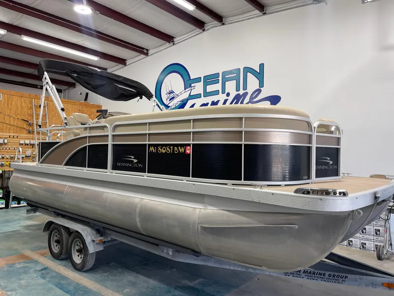 Slide: The Image of 2016 Bennington 22SX pontoon boat on trailer in showroom. - 1