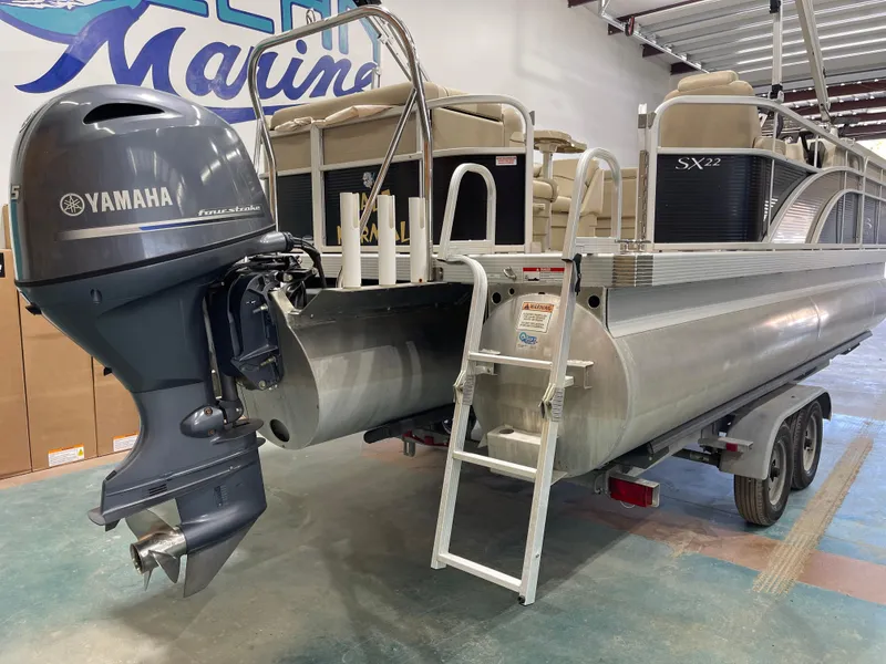 Slide: The Image of 2016 Bennington 22SX pontoon boat with Yamaha outboard motor on trailer in a showroom. - 10