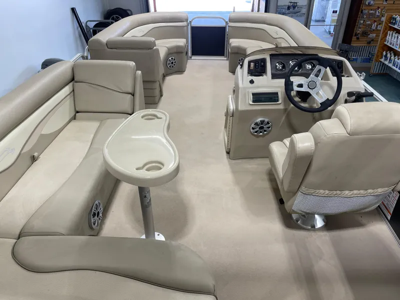 Slide: The Image of 2016 Bennington 22SX pontoon boat interior with beige seating and steering console. - 18