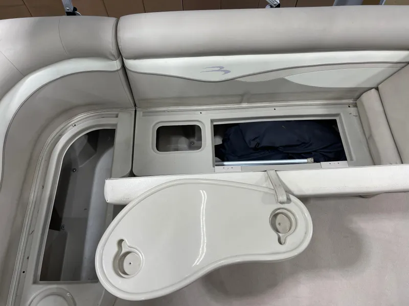 Slide: The Image of 2016 Bennington 22SX boat interior with storage compartments and cup holders. - 22