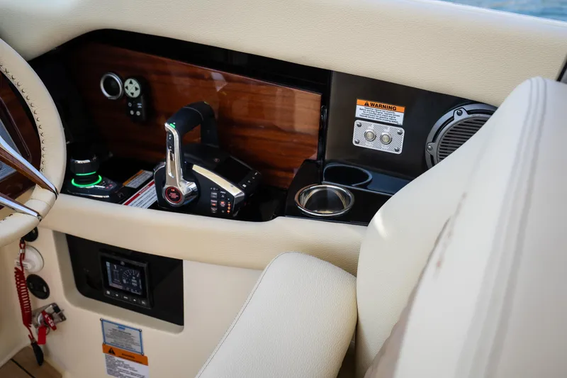 Slide: The Image of 2024 Chris-Craft Launch 35 GT helm with controls, cup holder, and wood paneling. - 24