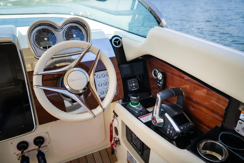 Slide: The Image of 2024 Chris-Craft Launch 35 GT dashboard with steering wheel and controls, featuring wood accents. - 25