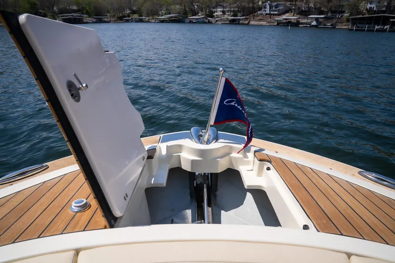 Slide: The Image of 2024 Chris-Craft Launch 35 GT boat bow with open hatch and flag on water. - 43