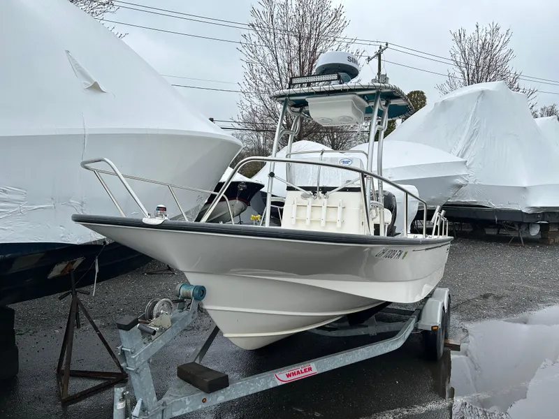 Slide: The Image of 2015 Boston Whaler 190 Montauk boat on trailer, parked outdoors, surrounded by covered boats. - 6