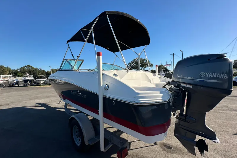 Slide: The Image of 2014 NauticStar 203DC Sport Deck boat with Yamaha outboard motor, parked on trailer. - 11