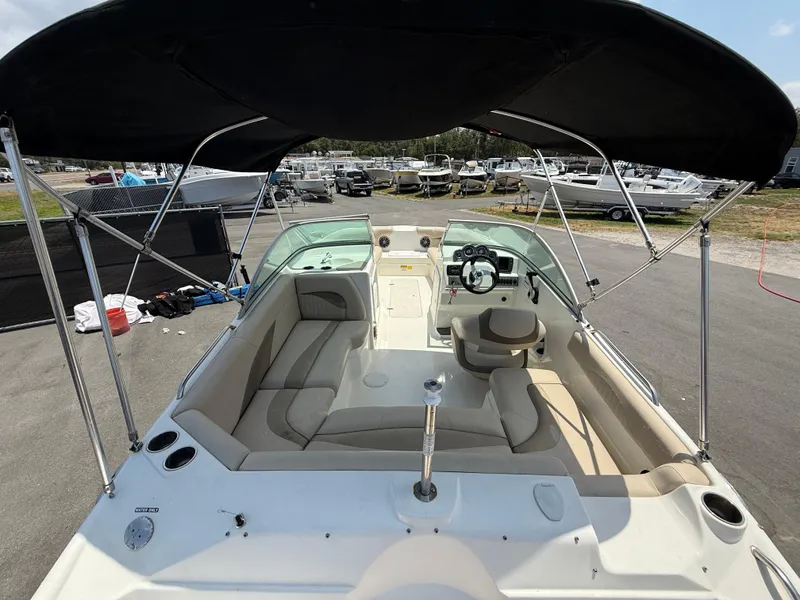 Slide: The Image of 2014 NauticStar 203DC Sport Deck boat with canopy, parked in a marina. - 12