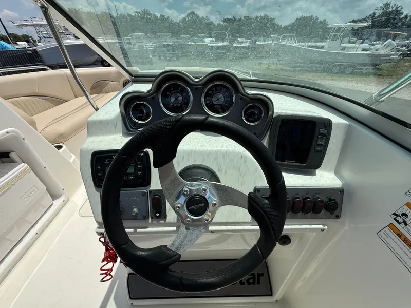 Slide: The Image of 2014 NauticStar 203DC Sport Deck dashboard with steering wheel and gauges. - 17