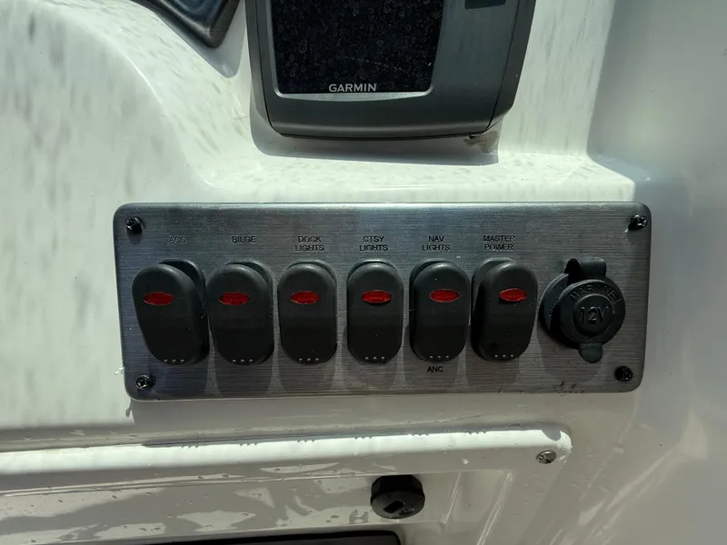 Slide: The Image of Control panel of 2014 NauticStar 203DC Sport Deck boat with switches and 12V outlet. - 18
