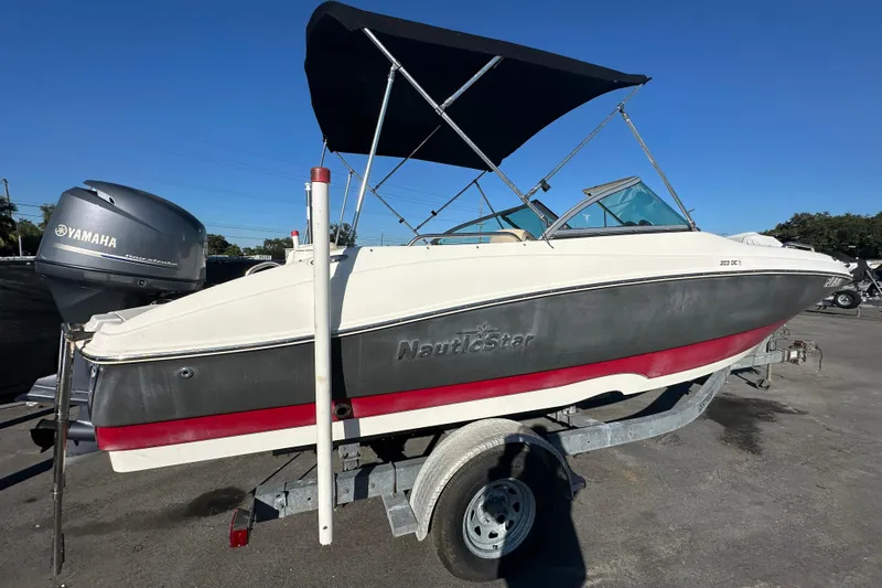 Slide: The Image of 2014 NauticStar 203DC Sport Deck boat on trailer with Yamaha outboard motor. - 2
