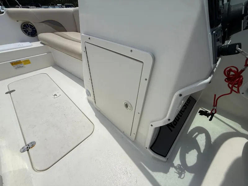 Slide: The Image of 2014 NauticStar 203DC Sport Deck interior with seating and storage compartments. - 20