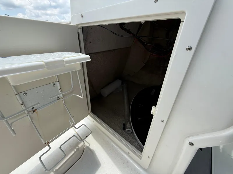 Slide: The Image of 2014 NauticStar 203DC Sport Deck storage compartment with open hatch and visible interior. - 21