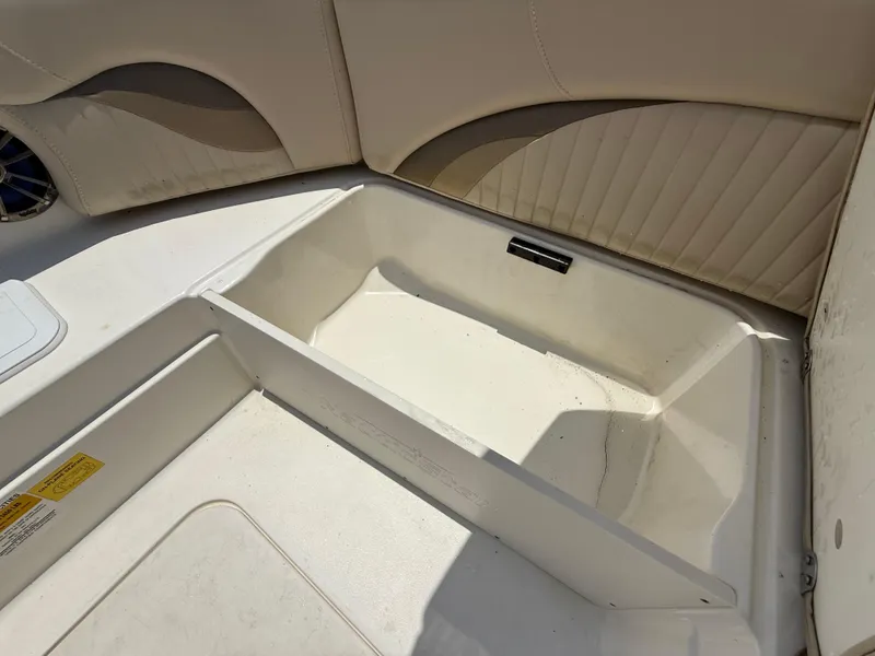 Slide: The Image of 2014 NauticStar 203DC Sport Deck boat storage compartment with beige seating. - 31