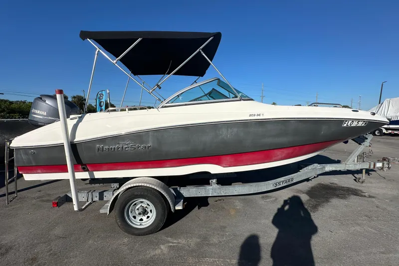 Slide: The Image of 2014 NauticStar 203DC Sport Deck boat on trailer with Yamaha engine, black canopy. - 4