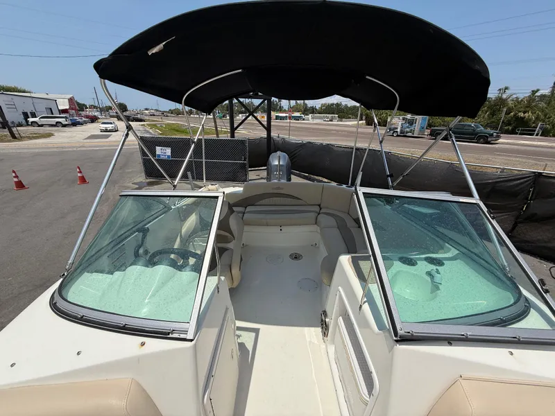Slide: The Image of 2014 NauticStar 203DC Sport Deck boat with black canopy, parked outdoors. - 43