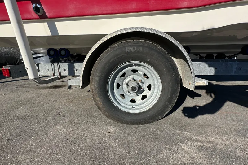 Slide: The Image of Trailer wheel of a 2014 NauticStar 203DC Sport Deck boat on pavement. - 9