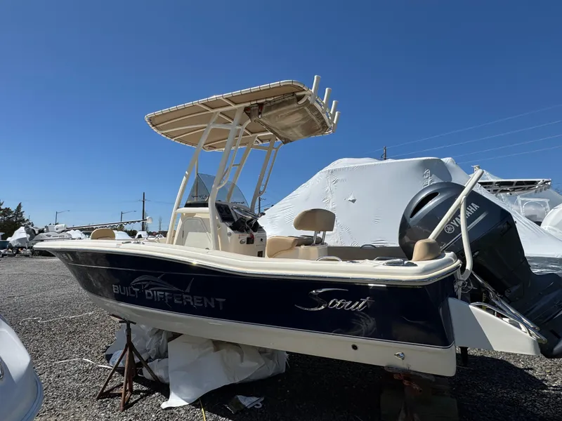 Slide: The Image of 2023 Scout 195 Sportfish boat with Yamaha engine, parked outdoors under clear blue sky. - 3