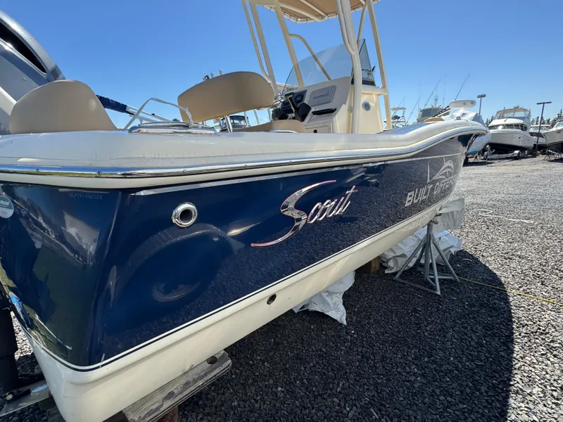 Slide: The Image of 2023 Scout 195 Sportfish boat, blue hull, parked on gravel lot. - 5