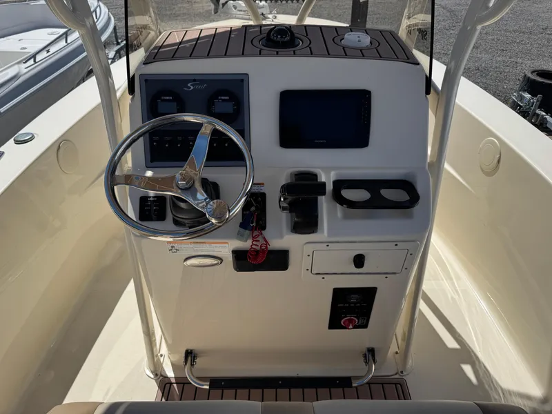 Slide: The Image of 2023 Scout 195 Sportfish boat console with steering wheel and navigation controls. - 6