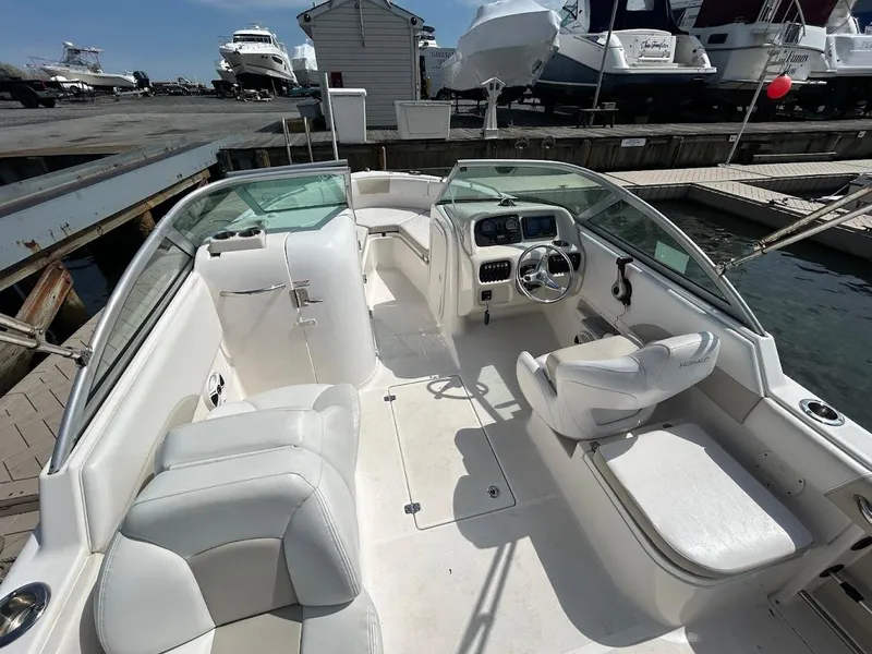 Slide: The Image of 2014 Robalo R227 boat interior with white seating, steering console, docked at marina. - 15