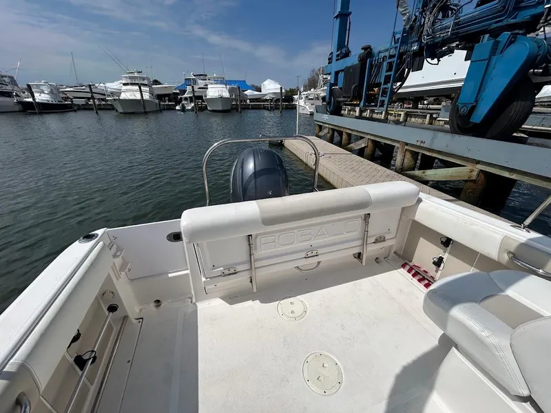 Slide: The Image of 2014 Robalo R227 boat docked at marina with other vessels in background. - 16