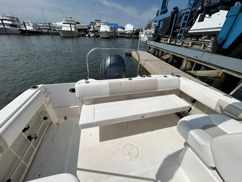 Slide: The Image of 2014 Robalo R227 boat interior at marina, featuring seating and engine view. - 17