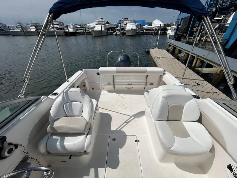 Slide: The Image of 2014 Robalo R227 boat interior with white seating, docked at marina. - 18