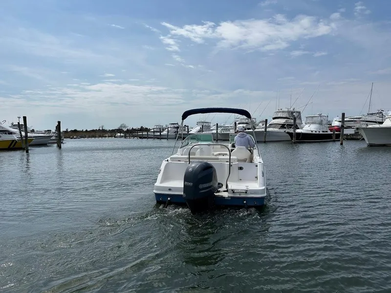 Slide: The Image of 2014 Robalo R227 boat navigating a marina with other vessels in the background. - 2