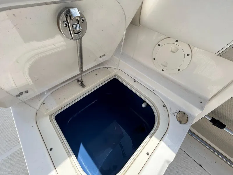 Slide: The Image of 2014 Robalo R227 boat livewell with open lid, showcasing interior storage space. - 20